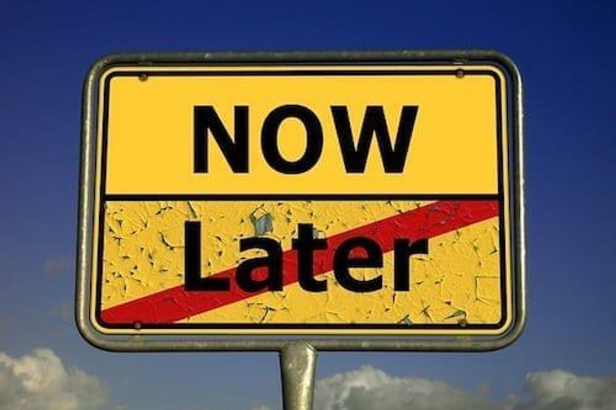sign saying "now" and "later" with "later" crossed out