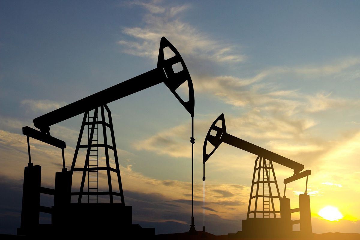 Silhouette of oil rigs against the sunset.