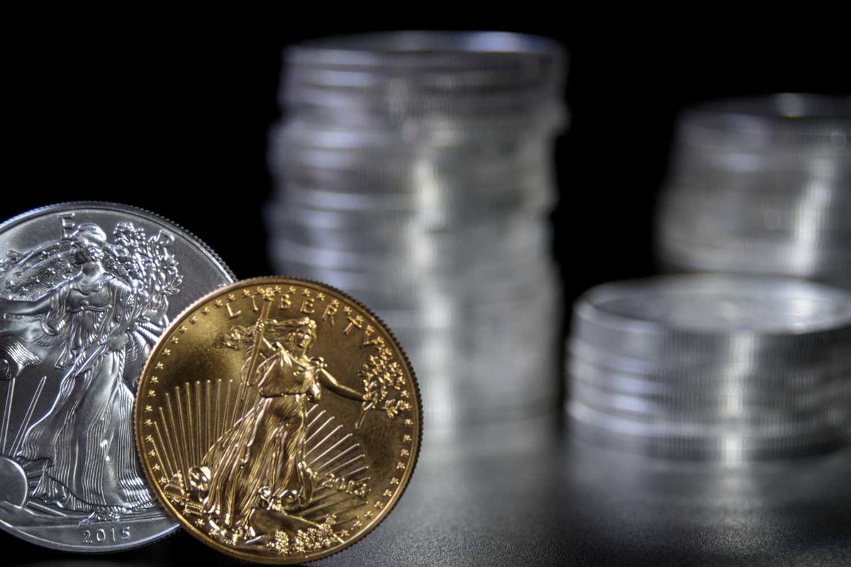 Silver and gold coins stacked, one 2015 coin in focus.