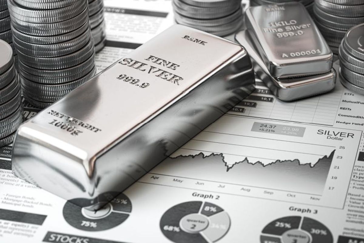 silver bars and coins with stock charts