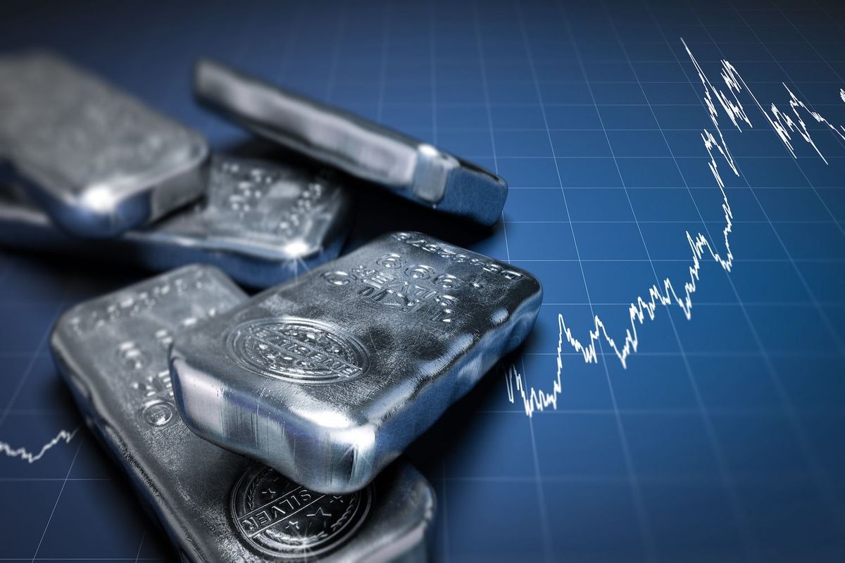 Silver bars on a rising stock market graph.