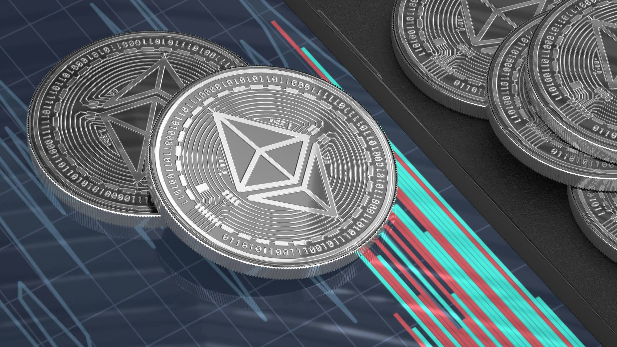 Silver cryptocurrency coins with geometric designs rest on a tablet displaying a digital chart with green and red lines.