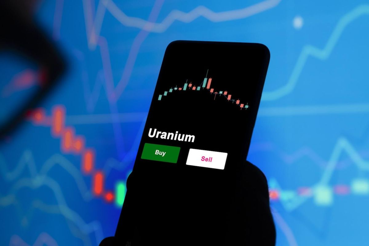 Smartphone displaying uranium stock chart with buy and sell options.