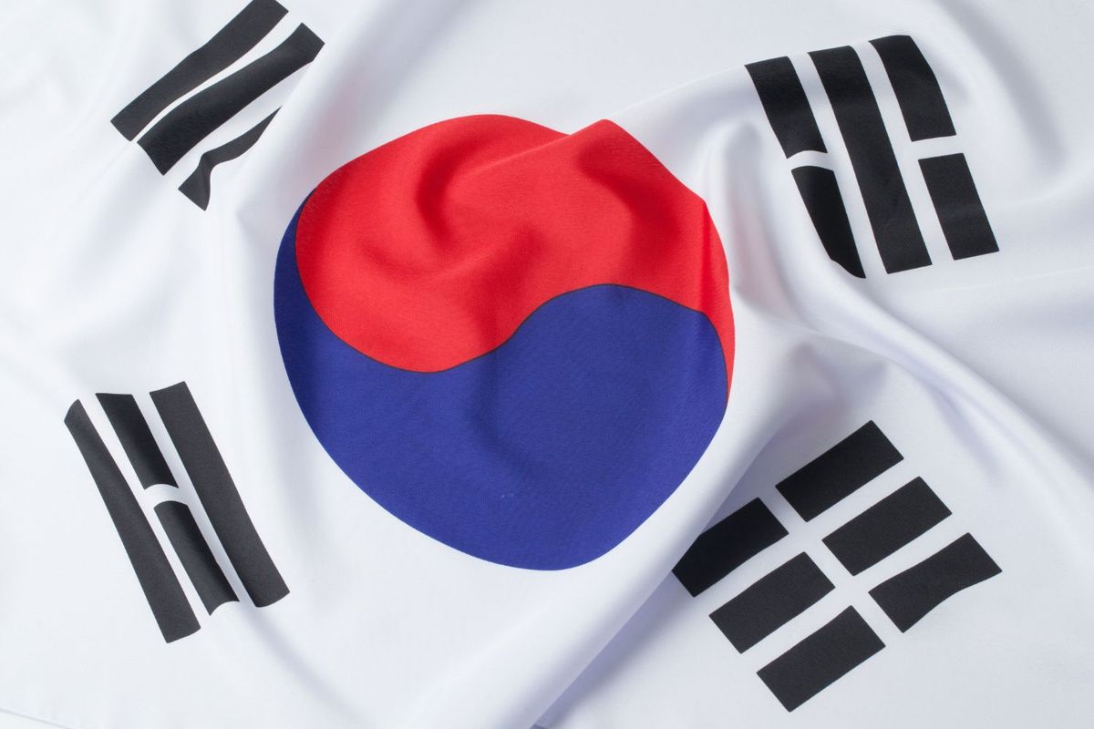 South Korean flag with a red and blue circle, black trigrams on white fabric.