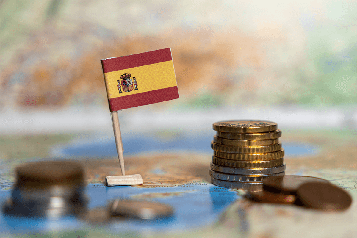 Spanish flag with stacked coins on a map