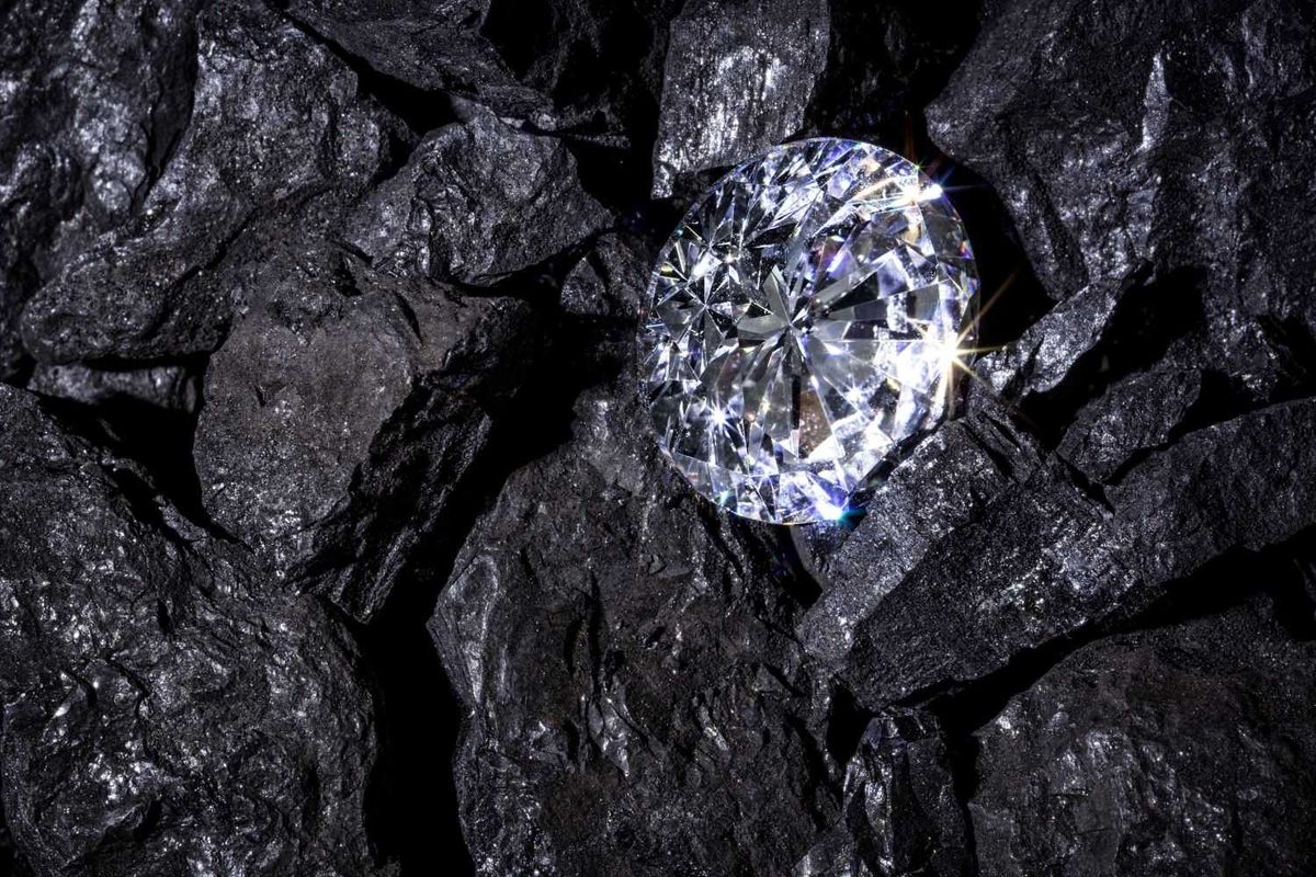 Sparkling diamond on dark ore rocks in mine.