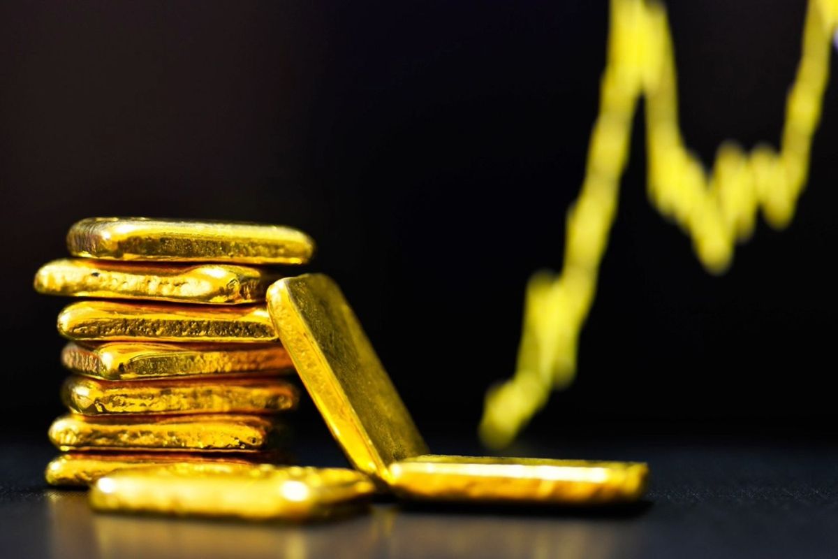Stack of gold bars with graph line in the background.
