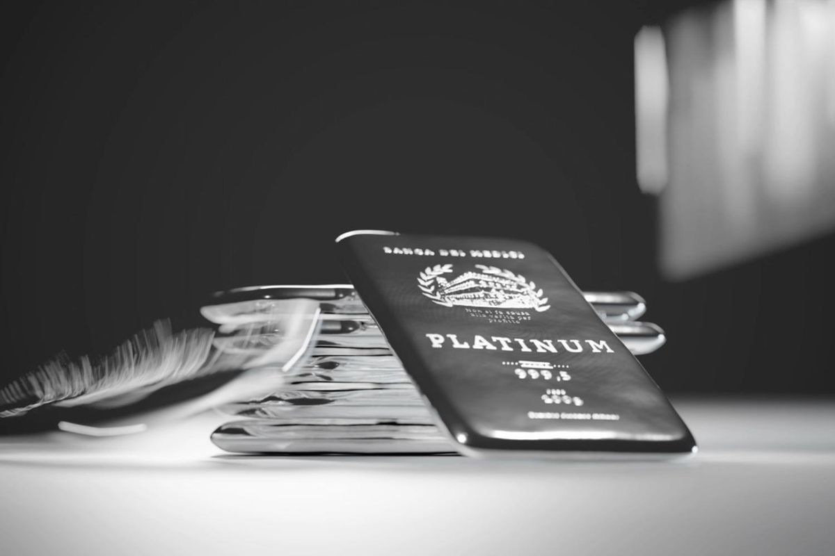 Stack of shiny platinum bars on a smooth surface.