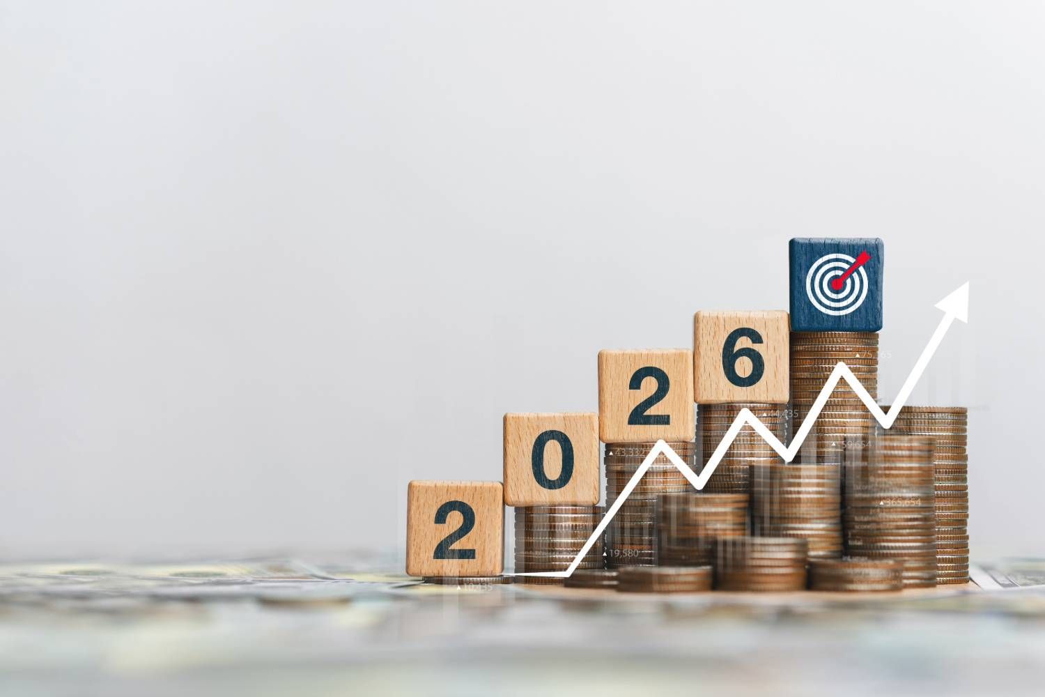 Stacked coins with 2026 blocks and upward arrow representing growth and goals.