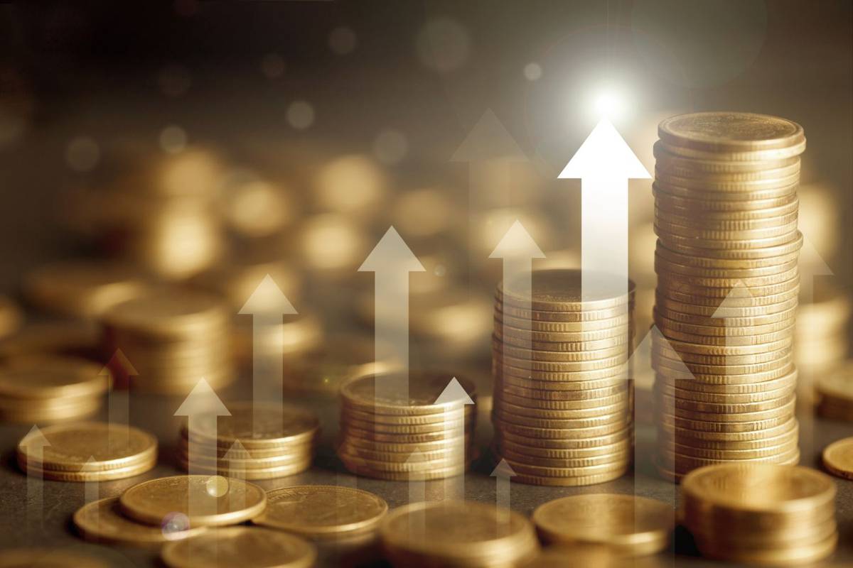 Stacks of gold coins with upward arrows symbolizing financial growth.