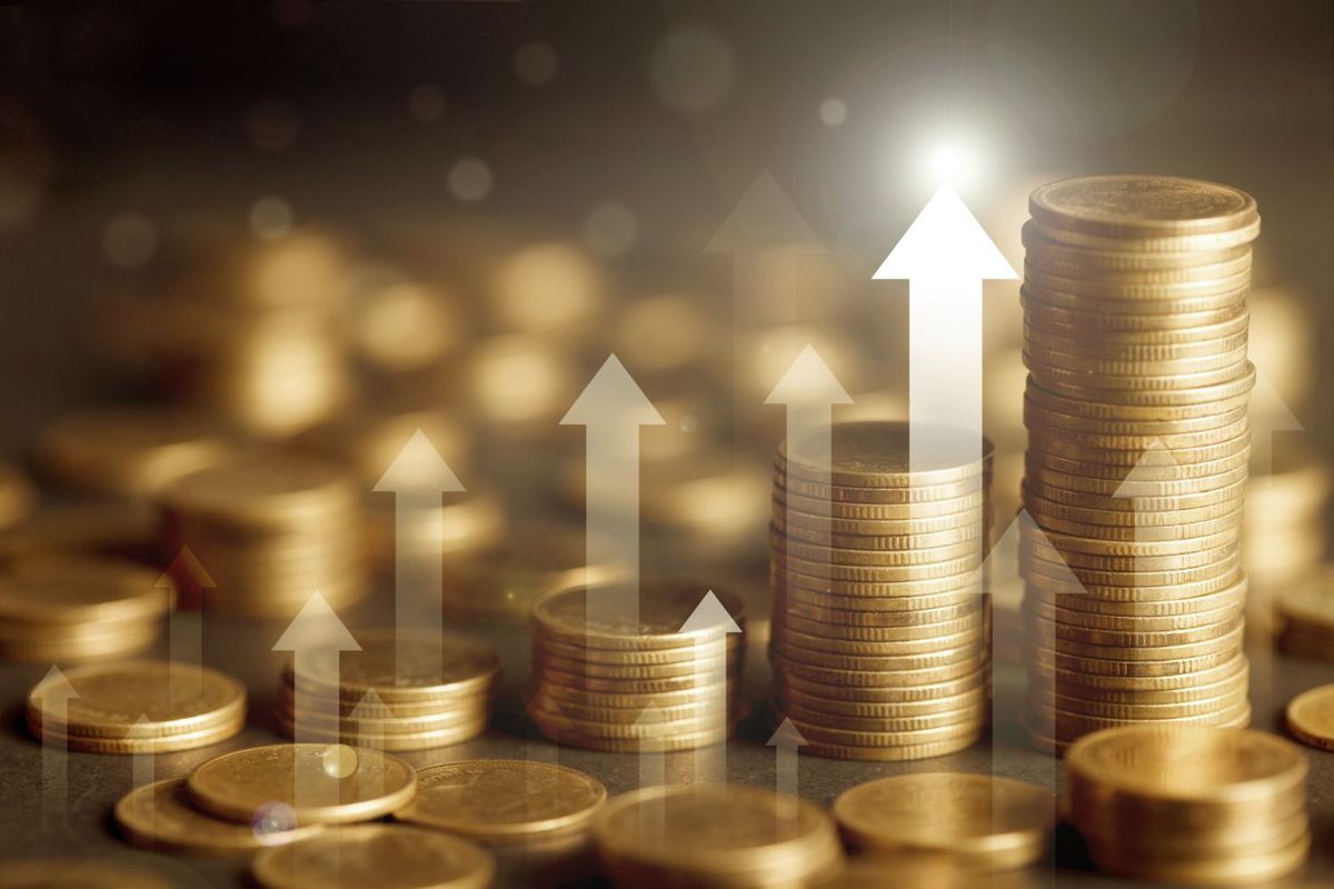 Stacks of gold coins with upward arrows symbolizing financial growth.