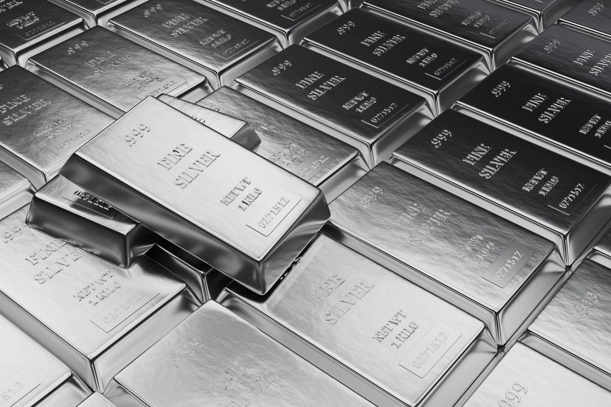 Stacks of shiny silver bars labeled "FINE SILVER" and "999" purity.