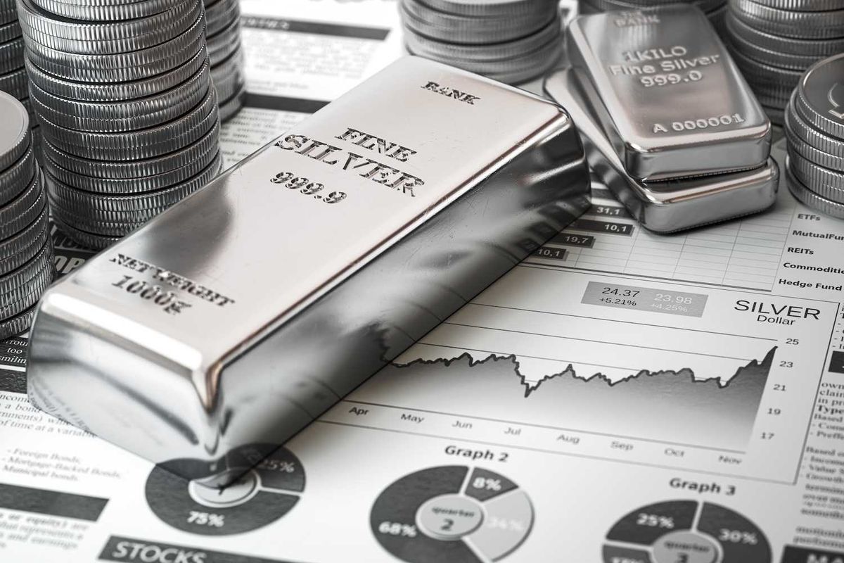 Stacks of silver bars and coins on financial charts.
