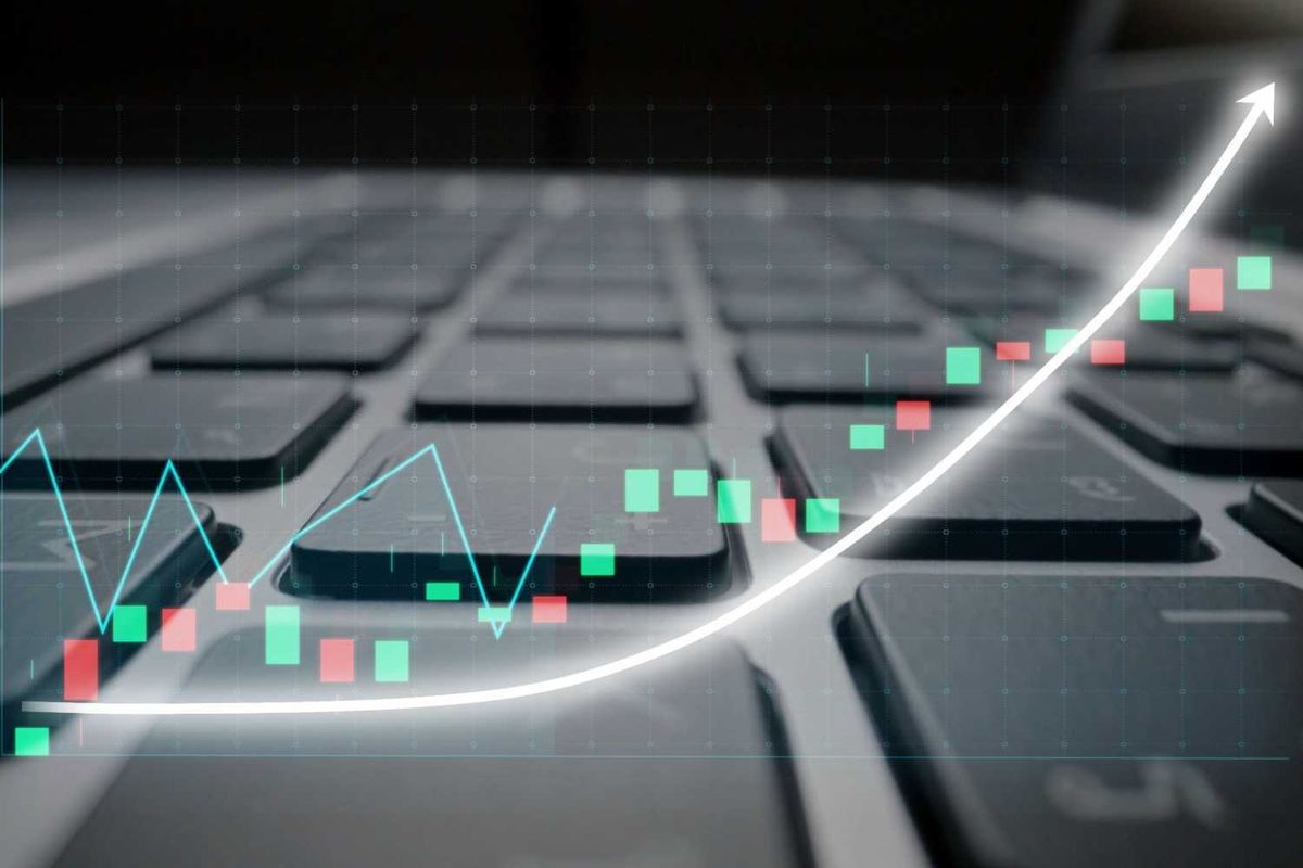 Stock chart overlay on a laptop keyboard symbolizes rising market trends.