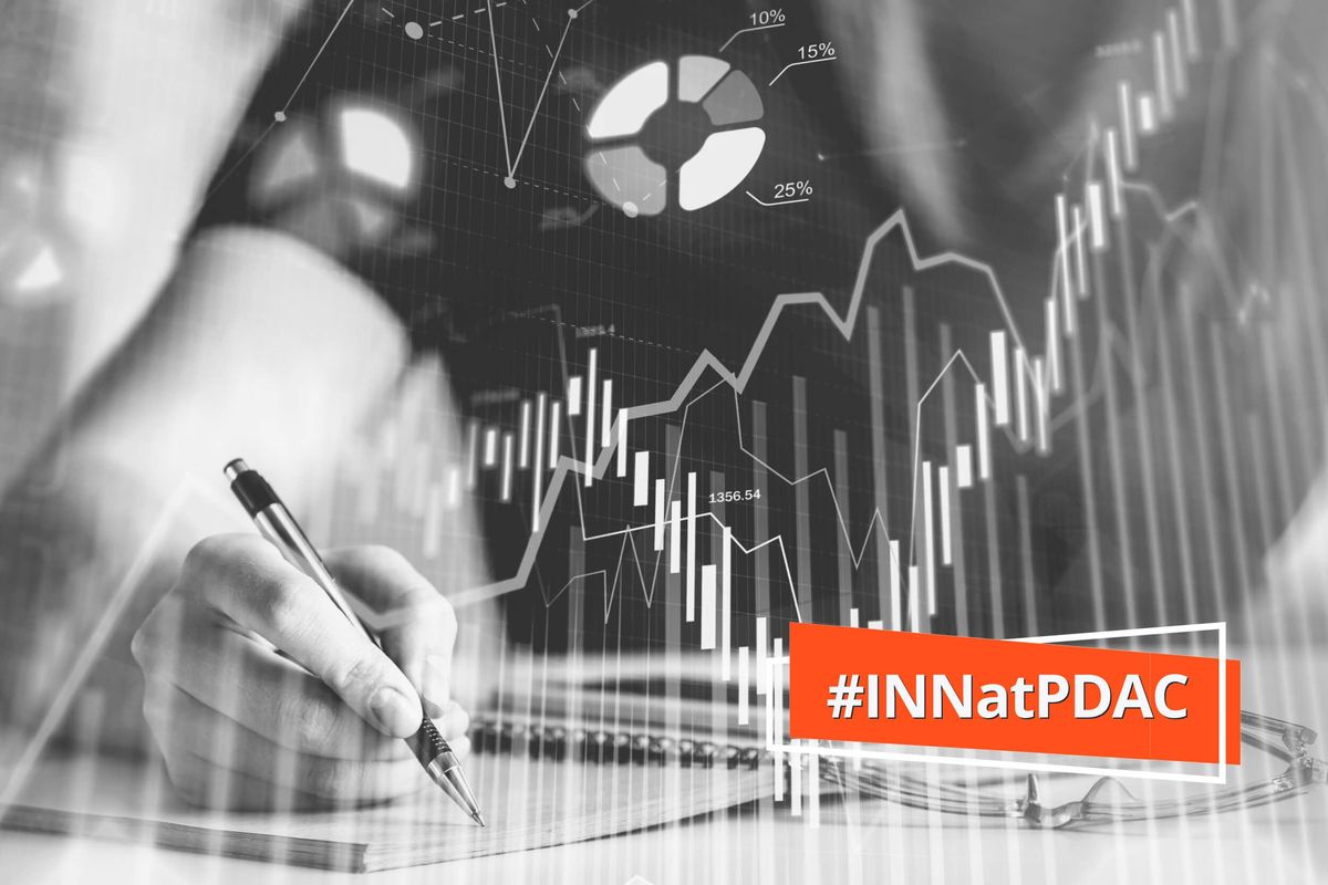 stock charts with hand holding pen