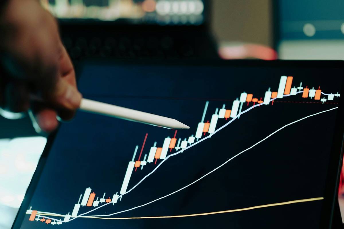 Stylus pointing at a financial chart on a tablet screen.