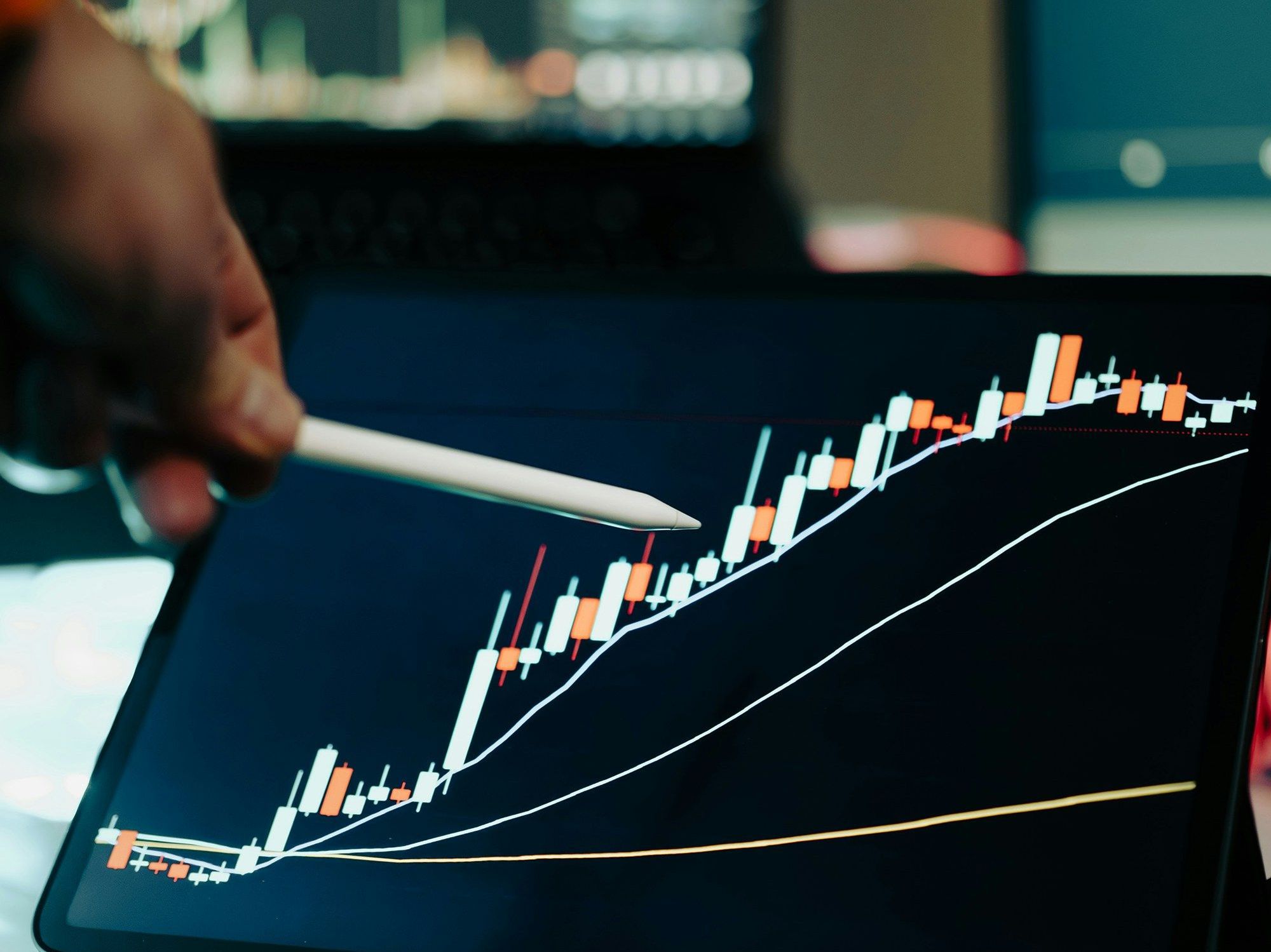 Stylus pointing at a financial chart on a tablet screen.