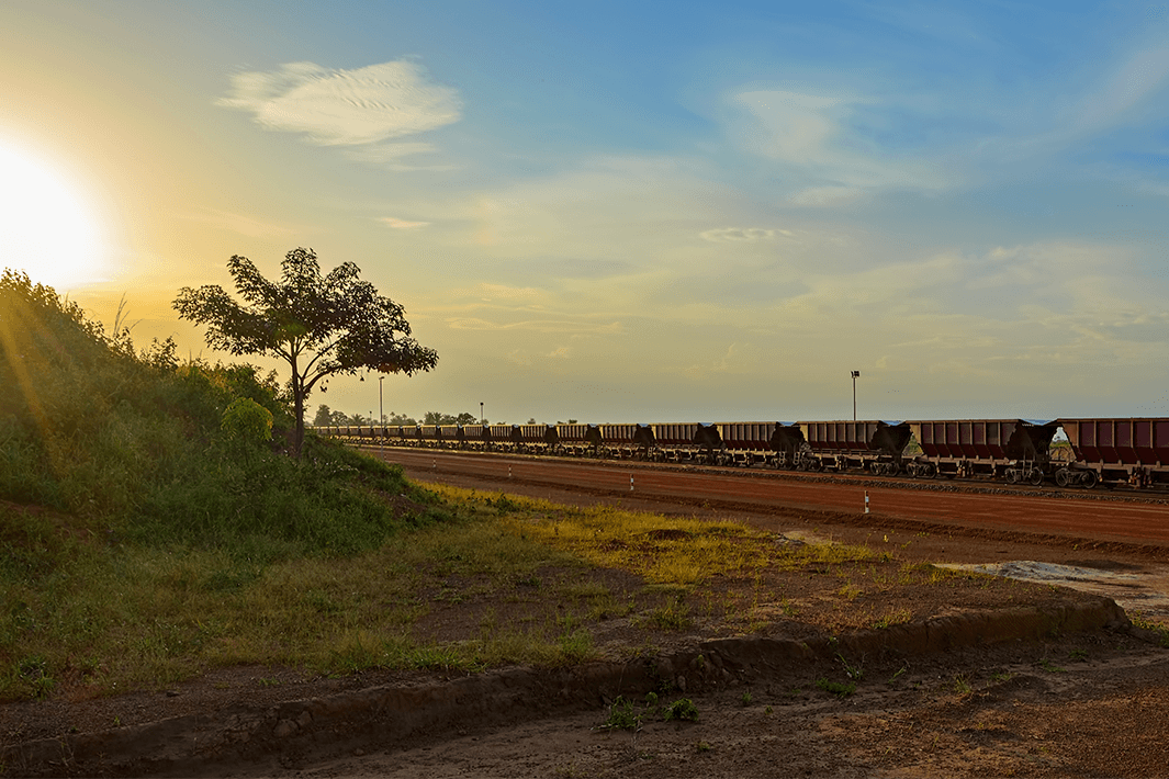 Sunset view to railway carriages for transportation of bauxite ore on train tracks