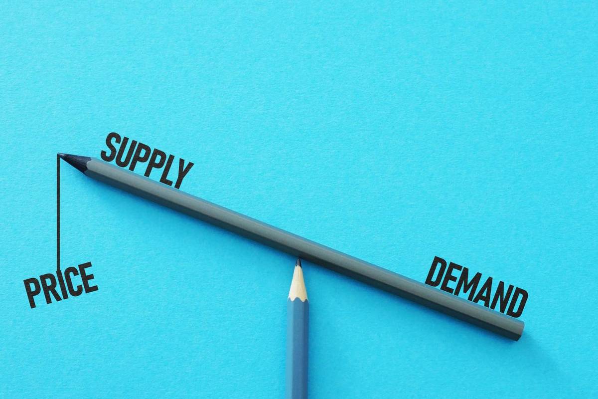 Supply/demand imbalance visualization using pencils on blue background.