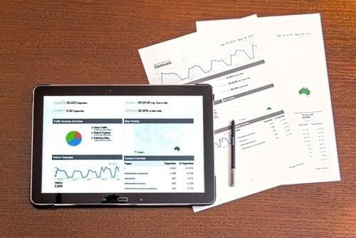  tablet and papers showing investment documents