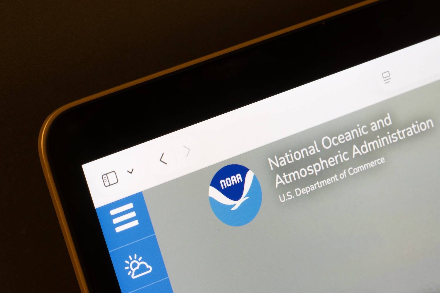 Tablet displaying NOAA website with blue logo on gray background.