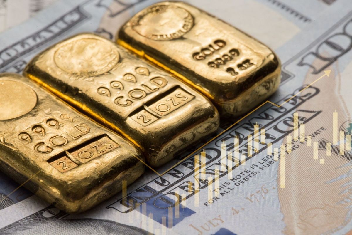 Three 2 ounce gold bullion bars on top of US dollar bills with gold-colored price chart on top.