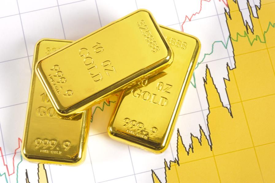 three gold bars atop a stock chart