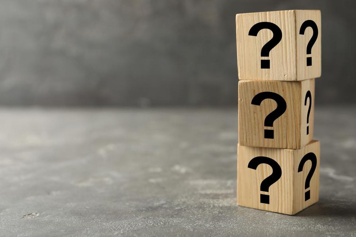 three stacked wooden blocks with question marks