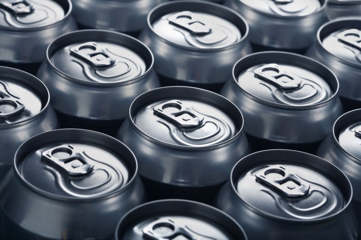 Tops of aluminum beverage cans lined up in rows.
