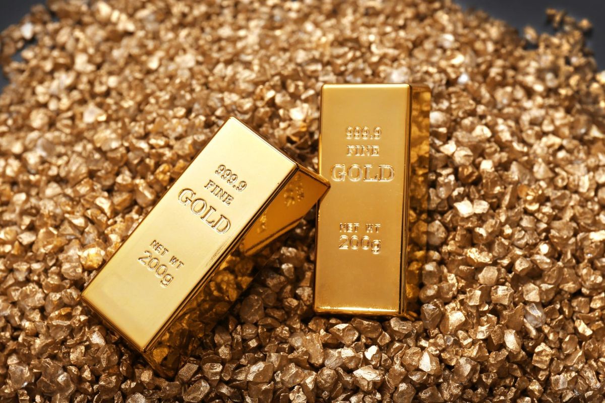 Two gold bars on a bed of gold nuggets.