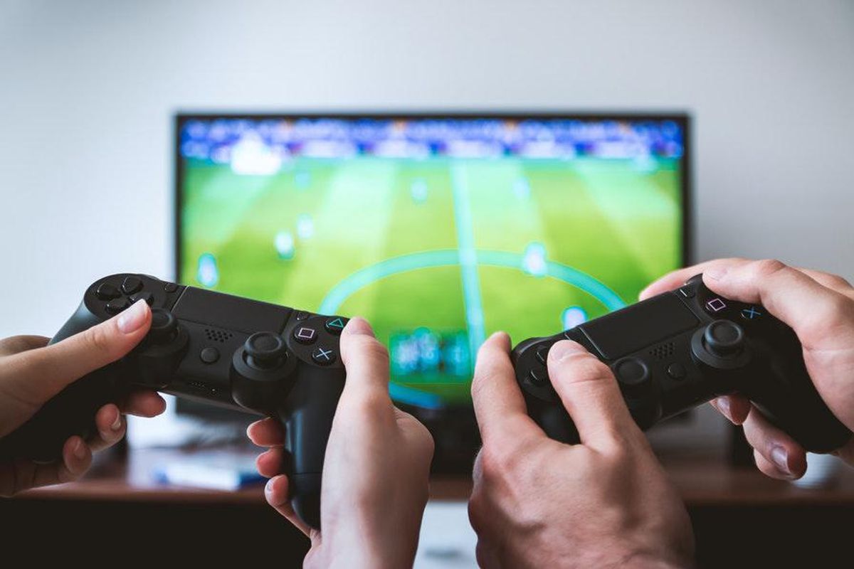 two people holding gaming controllers together