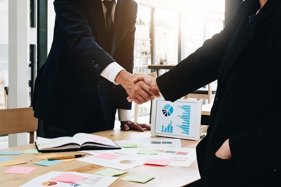 two people shaking hands to complete business agreement