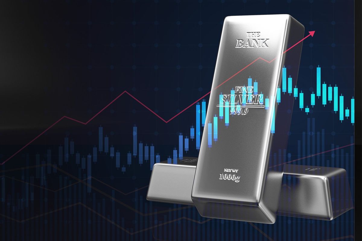 Two silver bars weighing 1000 grams in front of price charts.