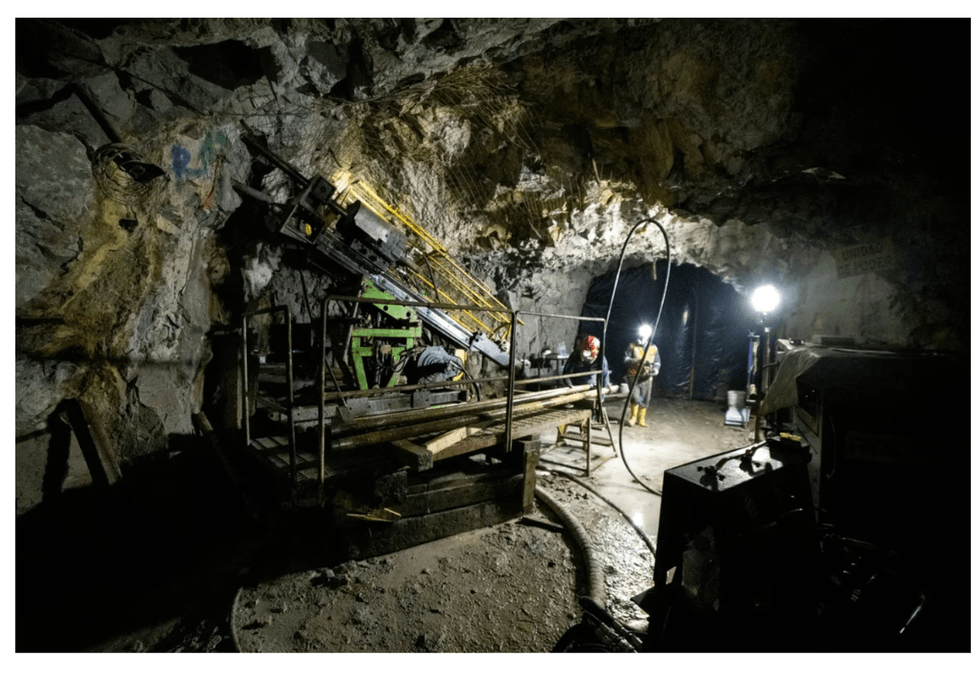 U92 Energy industrial machinery is surrounded by rocky walls and workers in protective gear illuminate the scene.