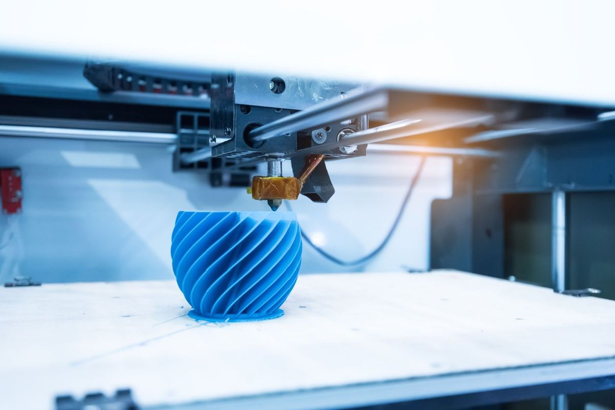 Up close 3D printer printing a blue spiral object.