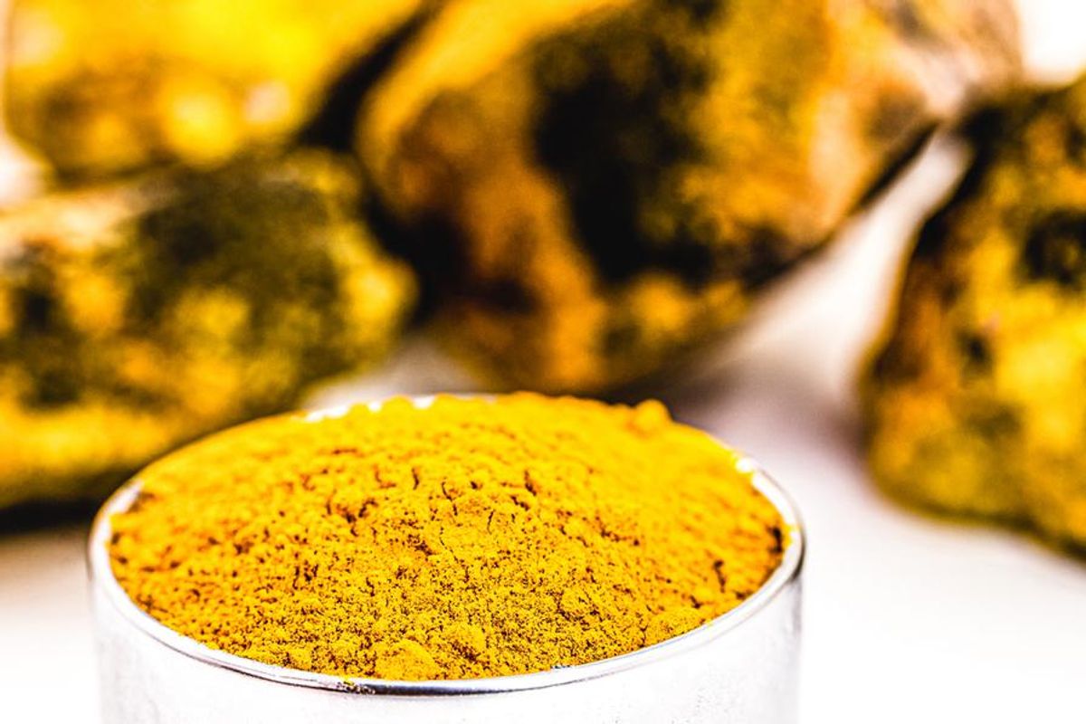 uranium yellowcake in a bowl in front of pieces of uranium ore