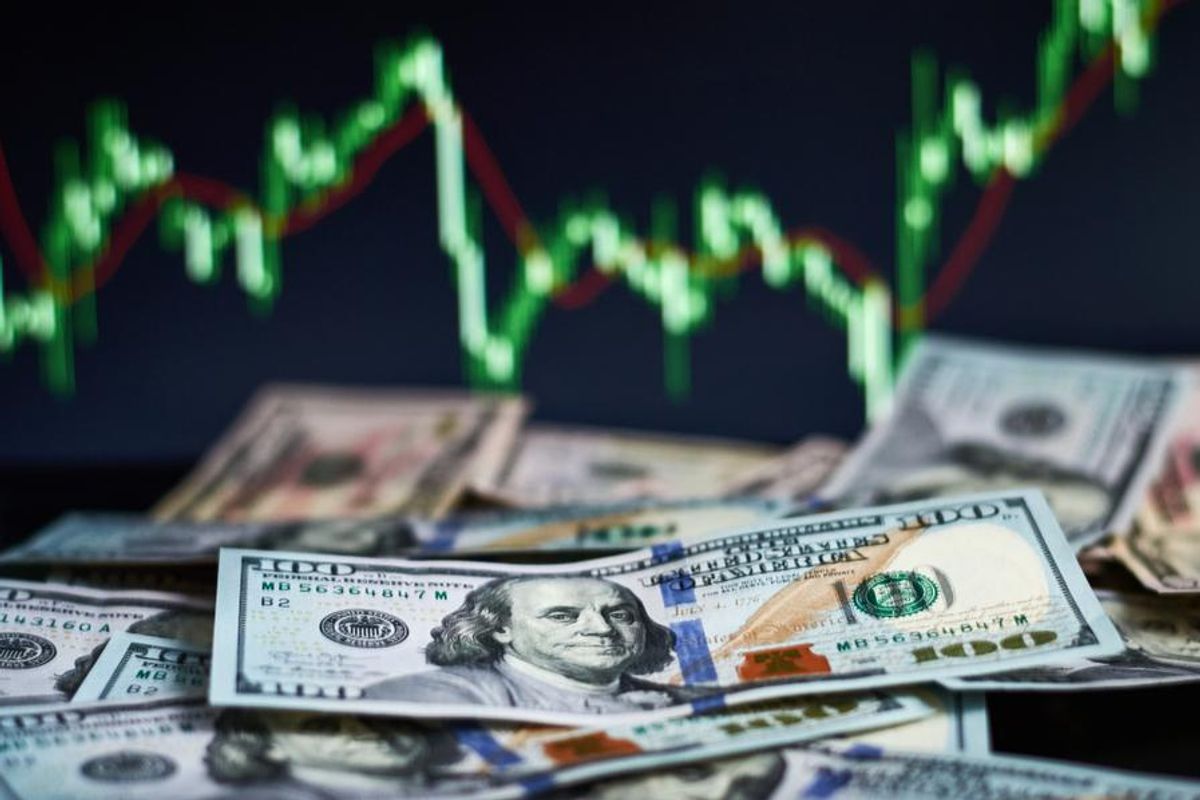US$100 bills with stock chart