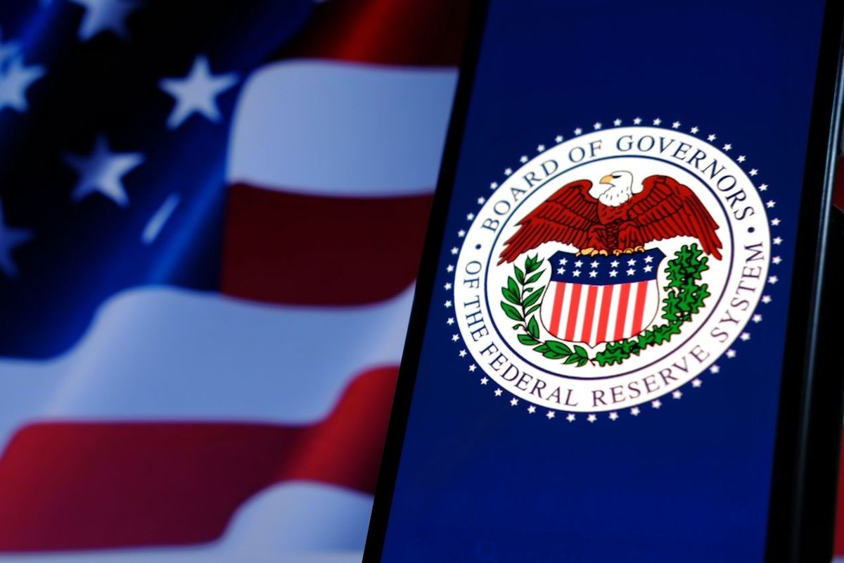US Federal Reserve logo on phone screen and an American flag.