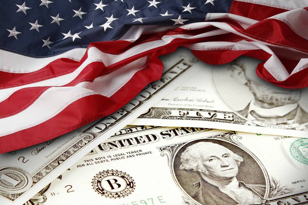 US flag draped over US$1 and US$5 bills featuring George Washington and Abraham Lincoln.