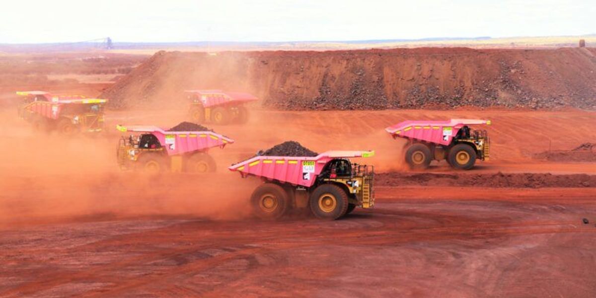 Vehicles hauling ore at Roy Hill iron ore mine.
