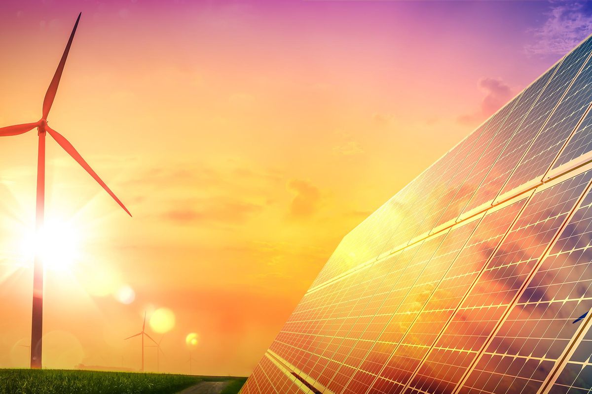 wind turbines and solar panels at sunset