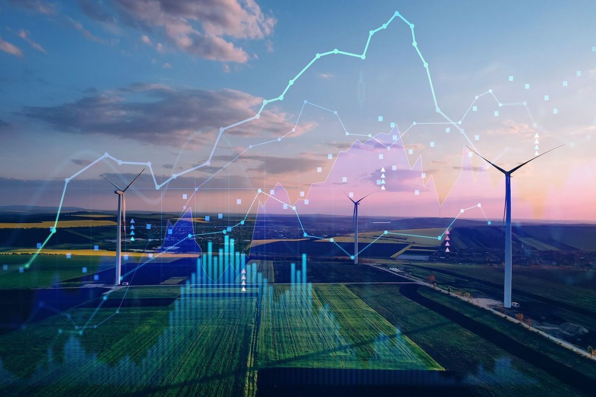 Wind turbines in a field with overlaid data graphs against a sunset sky.