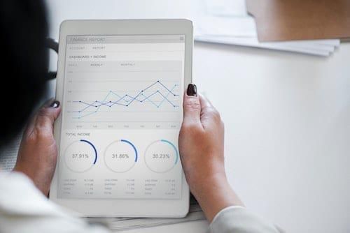 woman reading graphs and charts on a tablet