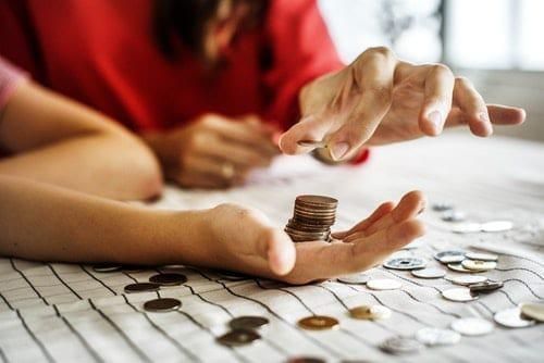 woman stacking coins in another person's hand