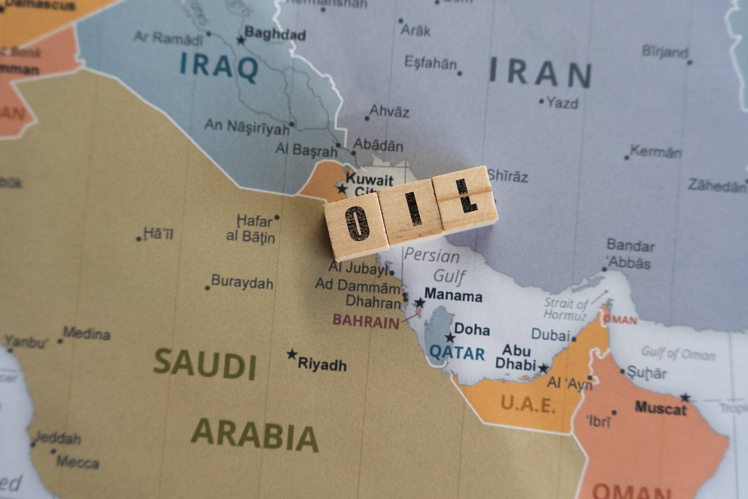 Wooden blocks spelling "oil" on a map showing Saudi Arabia, Iran and surrounding countries.