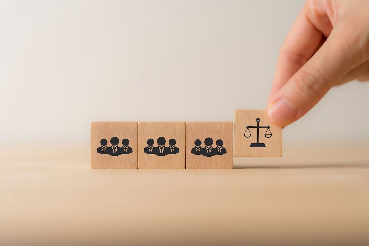 Wooden blocks with a group of people and a scale on them.