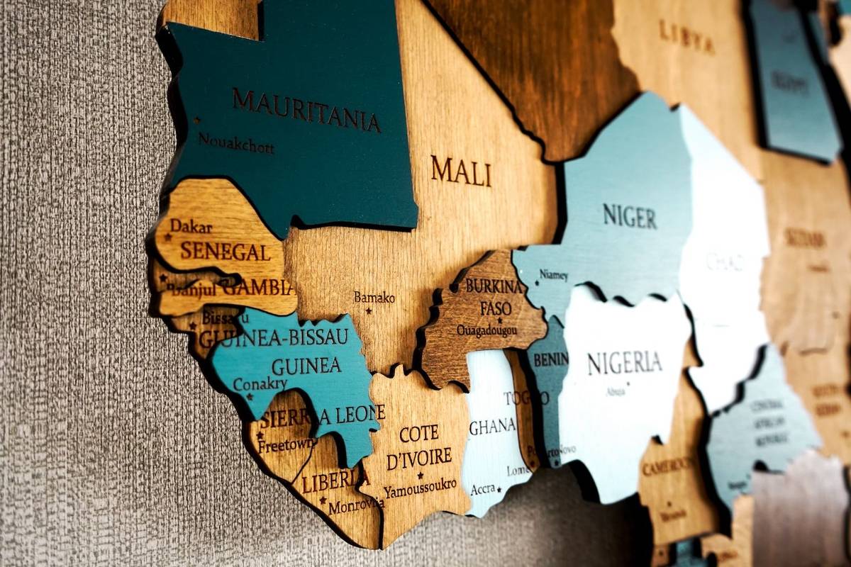 Wooden map of West Africa with labeled countries and capitals.