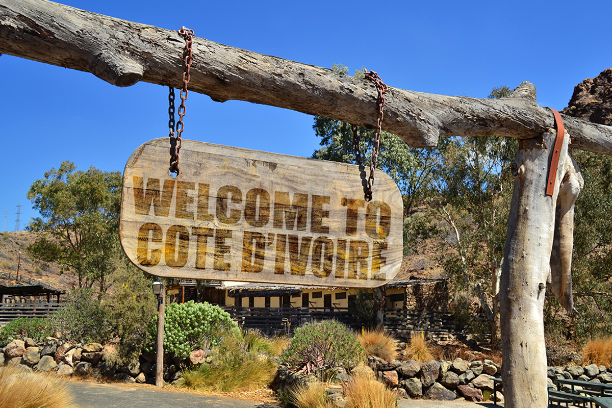 Wooden sign saying "Welcome to Côte d'Ivoire."