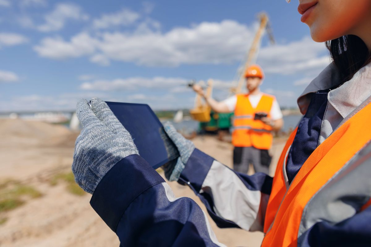 Worker inspecting open-pit mine sand quarry.