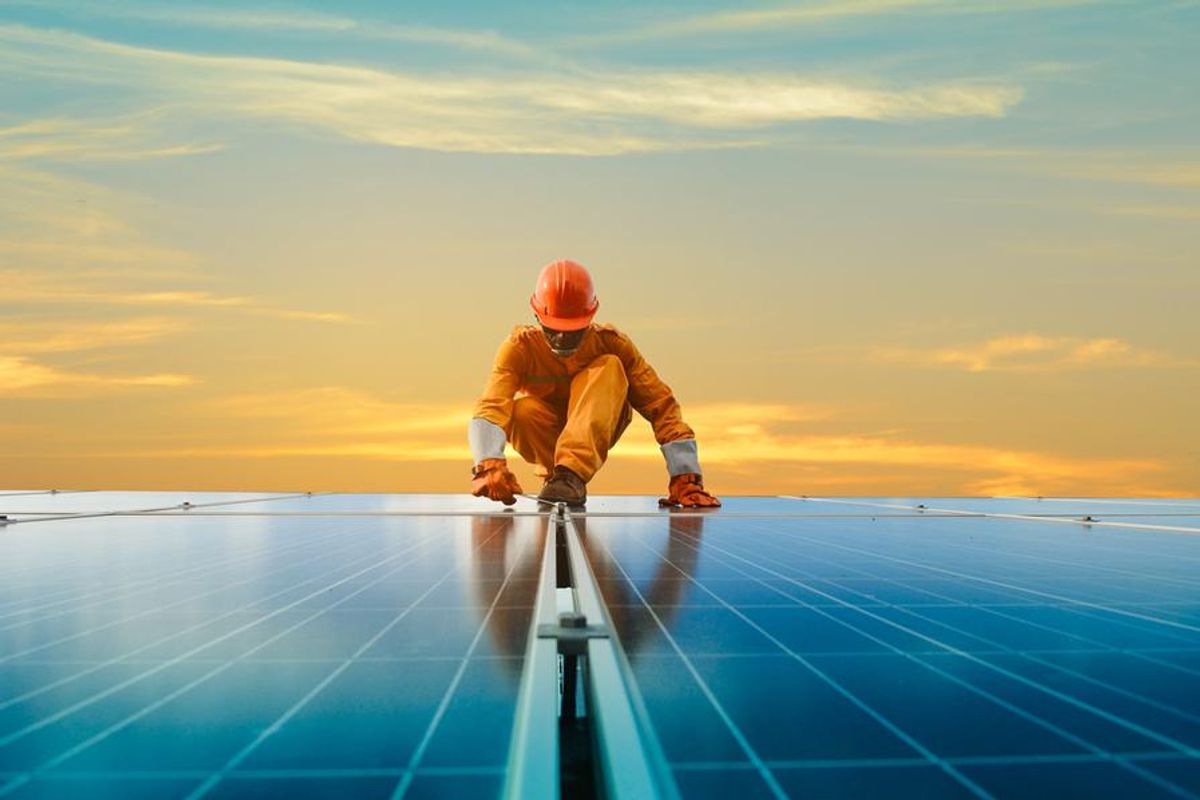 worker on solar panel roof